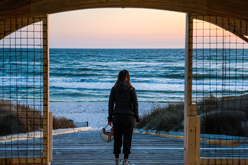 Figure looking toward the Gulf through a beach access pavilion